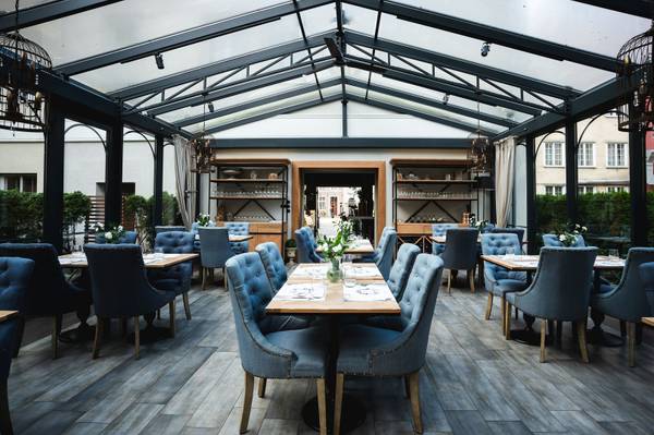 Widok na stoły, krzesła i oszklony dach w restauracji Piwna 47 Food & Wine.